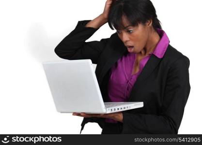 Woman looking in shock at her laptop