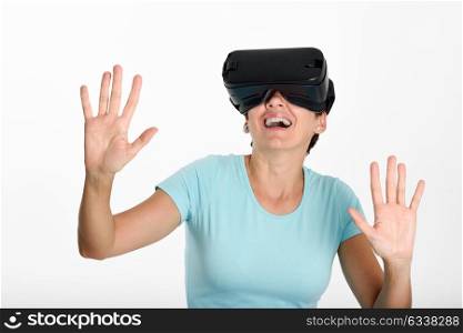 Woman looking in VR glasses and gesturing with his hands. Beautiful surprised female wearing virtual reality goggles watching movies or playing video games, isolated on white background.
