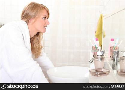 Woman looking into bathroom mirror