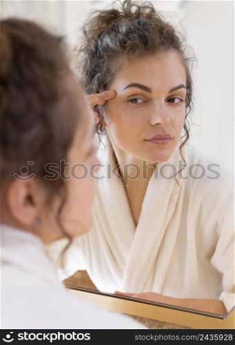 woman looking mirror doing beauty face routine