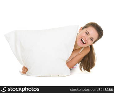 Woman looking out from pillow isolated on white