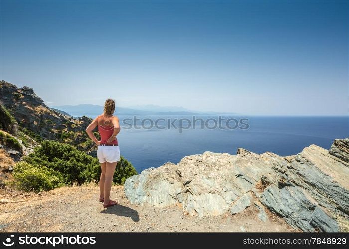 Woman looking out over the Mediterranean and Desert des Agriates from the west coast of Cap Corse in Corsica