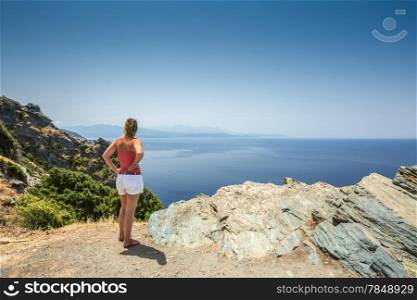 Woman looking out over the Mediterranean and Desert des Agriates from the west coast of Cap Corse in Corsica
