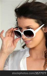 Woman looking over sunglasses