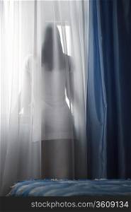 Woman looking through window, back view
