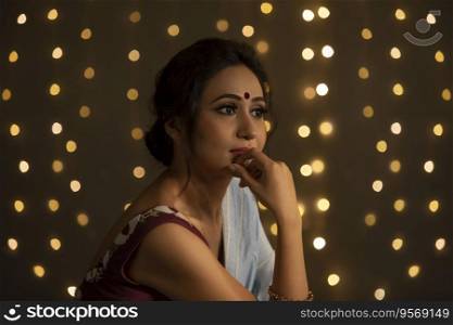 Woman lost in her thoughts with lights in the background