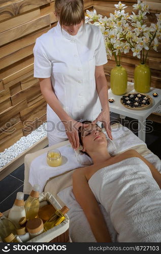 Woman lying down at luxury spa room getting head massage