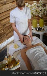 Woman lying down at luxury spa room getting head massage