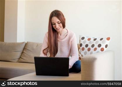 Woman lying down on couch with a laptop