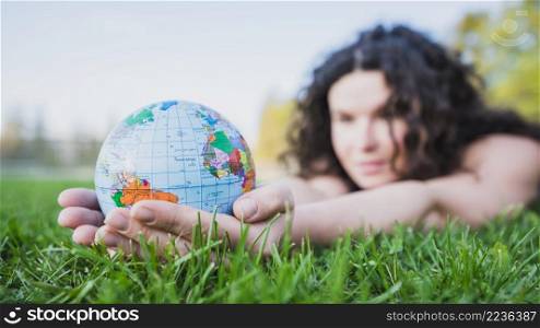 woman lying green grass holding globe hand green grass