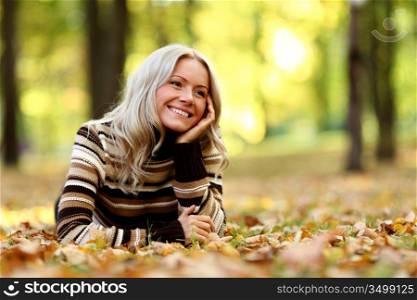 Woman lying in autumn leaves