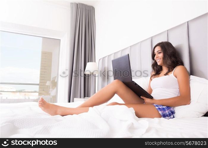 Woman lying in bed with her laptop