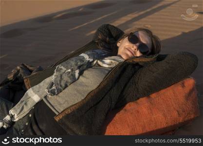 Woman lying in Erg Chegaga Dunes, Sahara Desert, Souss-Massa-Draa, Morocco