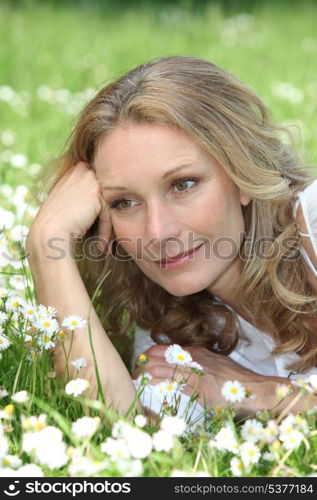 Woman lying in the daisies