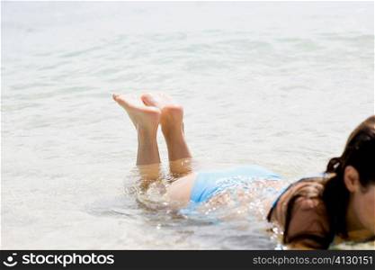 Woman lying in water on the beach