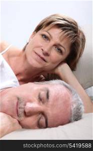 Woman lying next to her sleeping husband