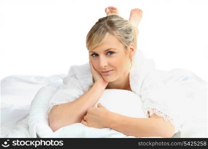 Woman lying on a white bed