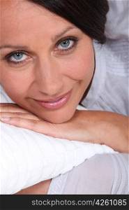 Woman lying on a white pillow