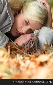Woman lying on an autumnal forest floor