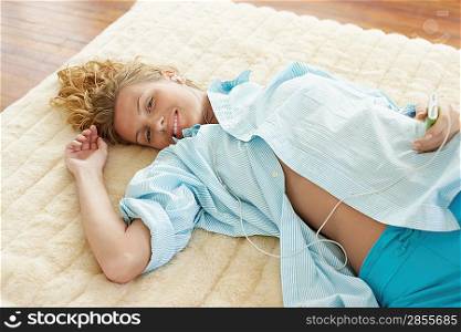 Woman Lying on Bed Listening to iPod