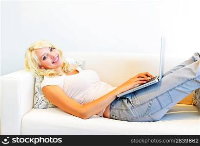 Woman lying on couch with laptop