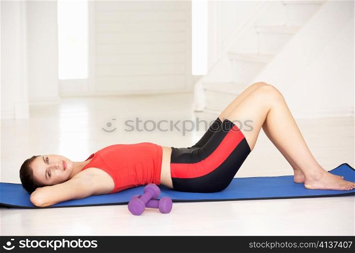 Woman lying on exercise mat