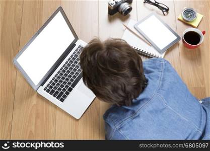 woman lying on floor using computer notebook with tablet and coffee cup