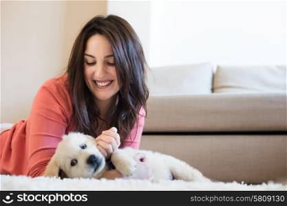 Woman lying on floor with a puppy