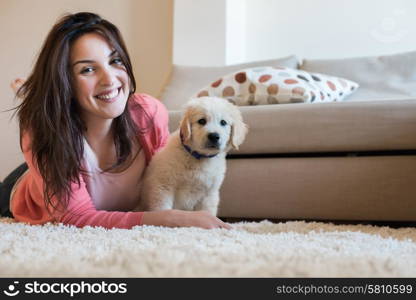 Woman lying on floor with a puppy