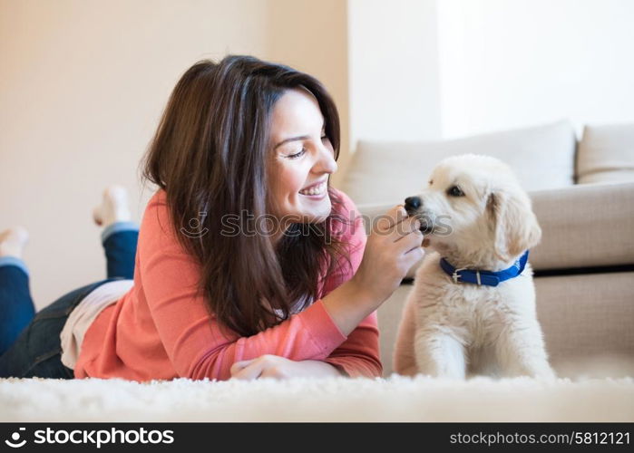 Woman lying on floor with a puppy