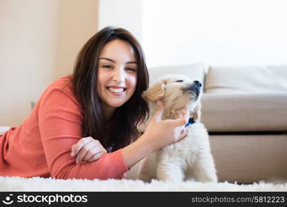 Woman lying on floor with a puppy