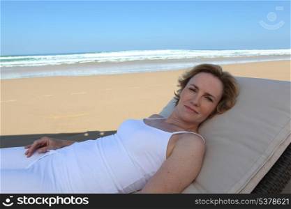 Woman lying on sun lounger