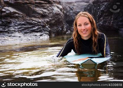 Woman lying on surfboard in the water
