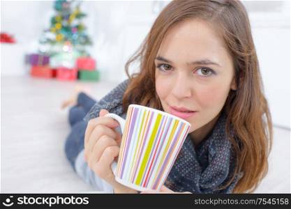 woman lying on the floor with a cup of tea