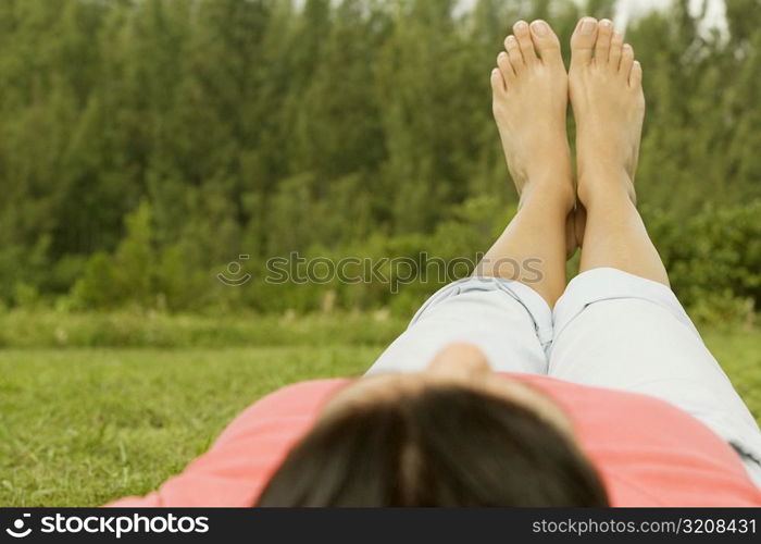 Woman lying on the grass with her feet up