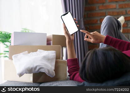 woman lying on the sofa playing on the phone shopping online