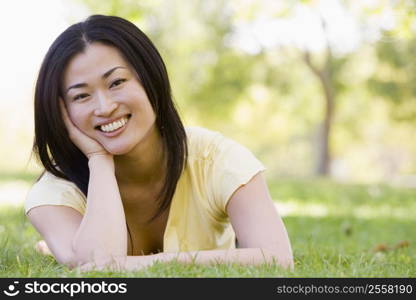 Woman lying outdoors smiling