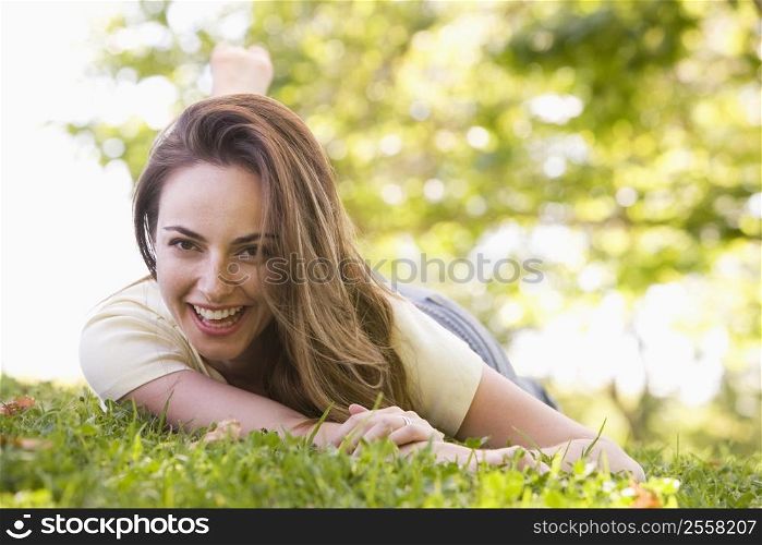 Woman lying outdoors smiling