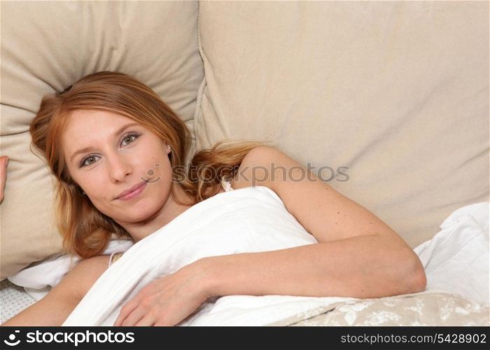 Woman lying under the covers