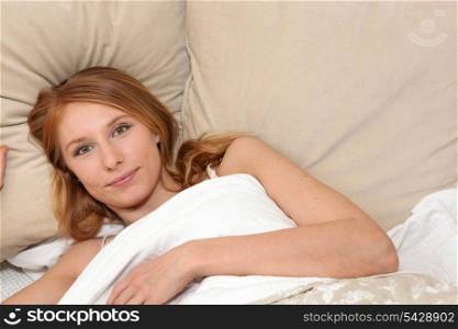 Woman lying under the covers