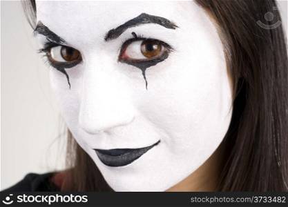 Woman made up in white face looks right into the camera