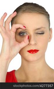 Woman making a circle with her fingers around her eye