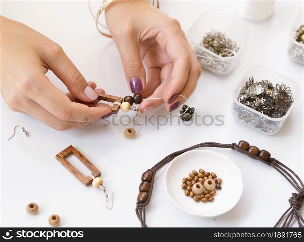 woman making accessories with wooden beads. Resolution and high quality beautiful photo. woman making accessories with wooden beads. High quality and resolution beautiful photo concept