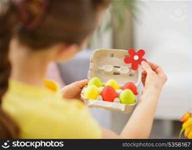 Woman making Easter decoration with colorful eggs