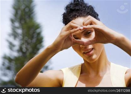 Woman making heart shape with her hands in front of her face