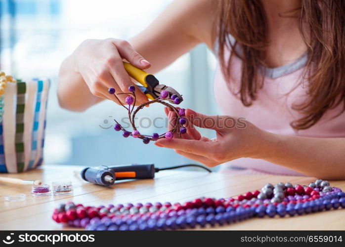 Woman making jewelry at home