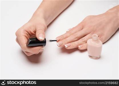Woman making manicure by herself on grey background.. Woman making manicure by herself on grey background