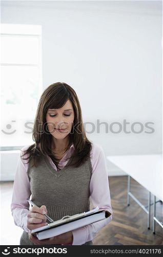 Woman making notes on clipboard