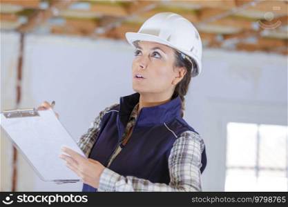 woman making notes on clipboard at property renovation site