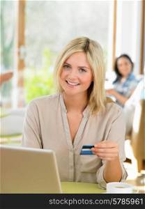 Woman Making Online Purchase In Cafe